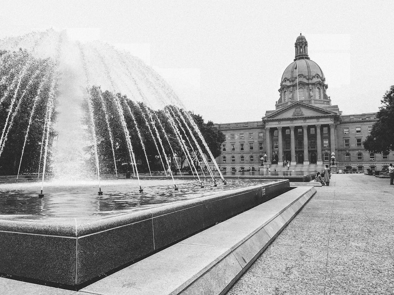 Black and white image of the Alberta Legislature Building with a foreground fountain in Edmonton, Canada.
